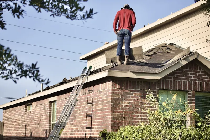 Professional roofer working on a residential roof in West Pleasant View